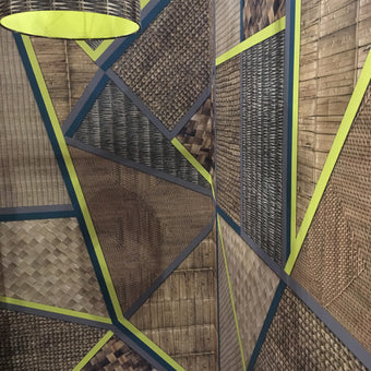 A section of wicker geometric mural wallpaper with geometric angles and shapes in natural and artificial colors.