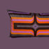 A rectangular velvet cushion with a multicolored geometric pattern, featuring stripes in shades of purple, orange, and gray.