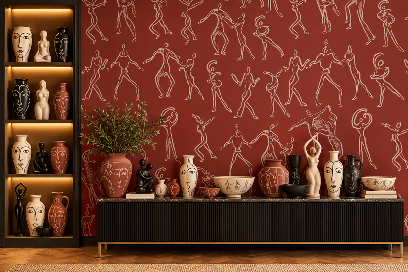 A styled interior scene with terracotta wallpaper featuring white line-drawn human figures, a black sideboard with decorative vases and sculptures, and a built-in shelving unit on the left with warm lighting.