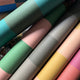 Rolls of colorful wallpaper in various shades.