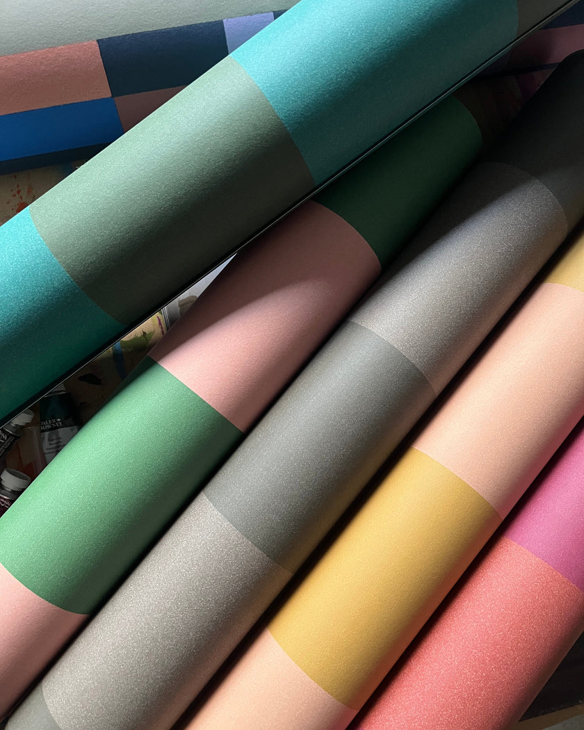 Rolls of colorful wallpaper in various shades.